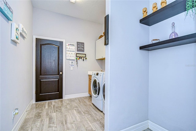 laundry area with a textured ceiling, cabinets, independent washer and dryer, and light wood-type flooring