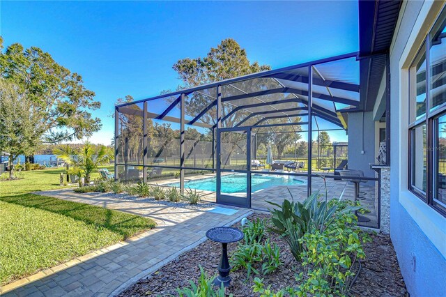 view of pool with glass enclosure and a lawn