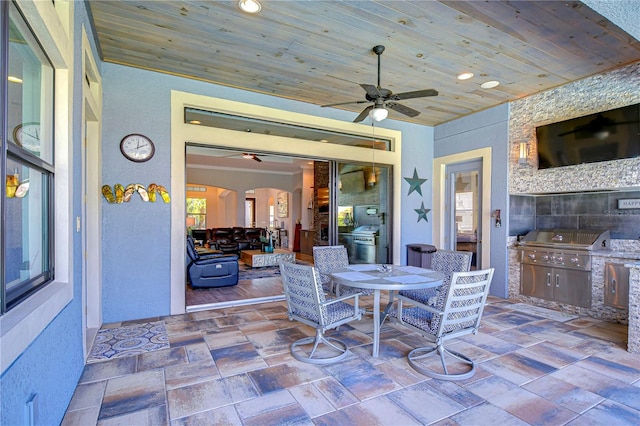 view of patio featuring a grill, ceiling fan, and an outdoor kitchen