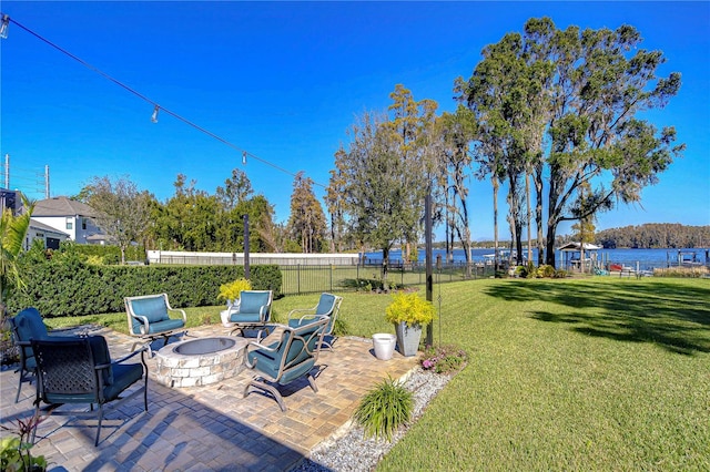 view of yard featuring a patio, a water view, and an outdoor fire pit