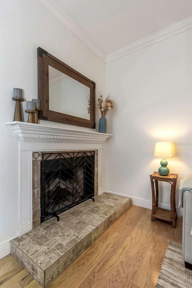 details featuring hardwood / wood-style floors, crown molding, and a tiled fireplace