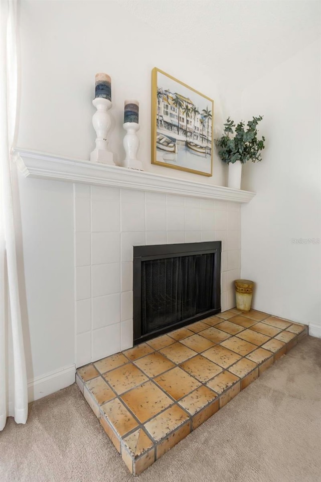 room details featuring a tile fireplace and carpet floors