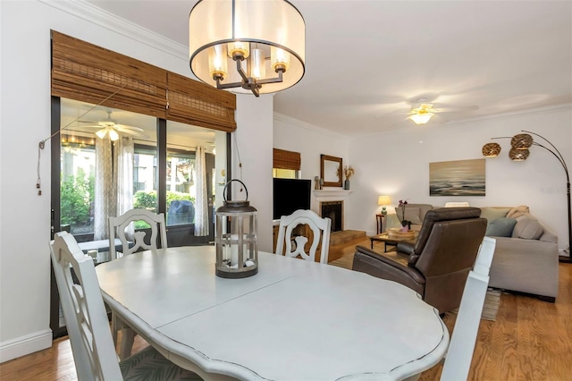 dining room featuring ceiling fan with notable chandelier, light hardwood / wood-style floors, and ornamental molding