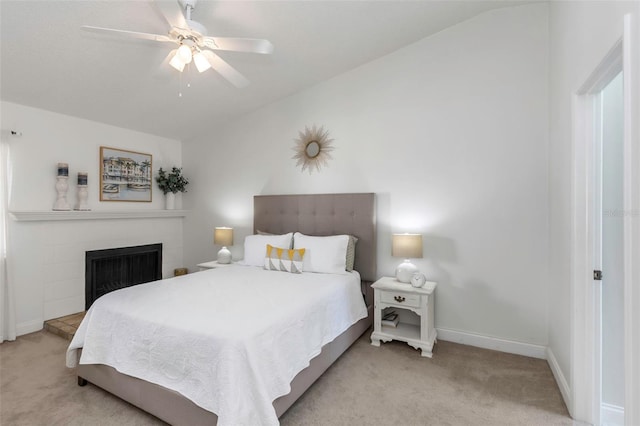 carpeted bedroom featuring ceiling fan and a fireplace