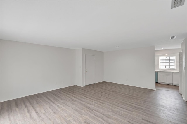 empty room featuring light wood-type flooring and sink