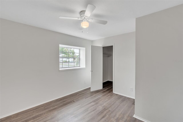 unfurnished bedroom with hardwood / wood-style floors, a closet, and ceiling fan