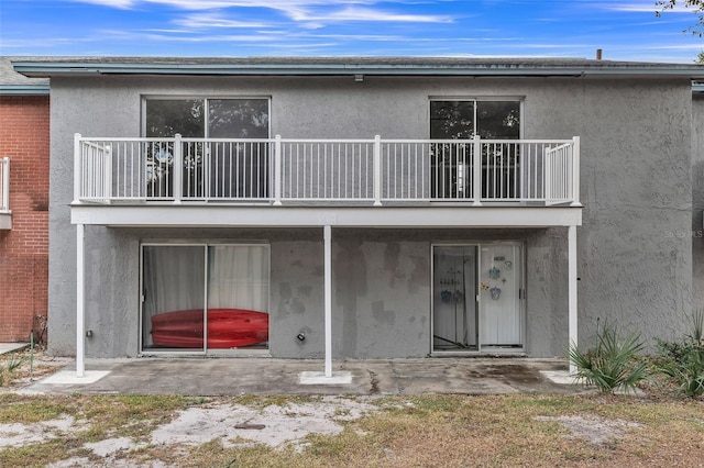 back of house with a balcony and a patio