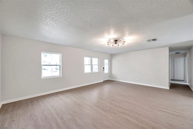 unfurnished room with a textured ceiling and dark hardwood / wood-style floors