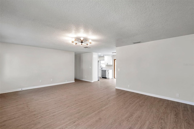 unfurnished living room with hardwood / wood-style floors and a textured ceiling