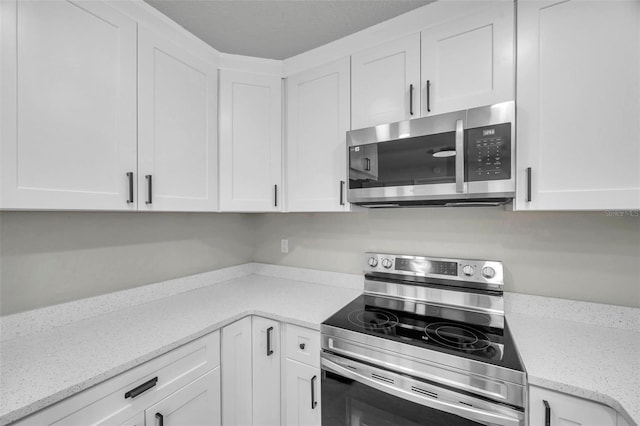 kitchen featuring light stone counters, white cabinets, and appliances with stainless steel finishes