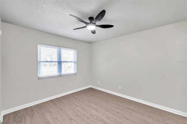 empty room with ceiling fan, a textured ceiling, and light wood-type flooring