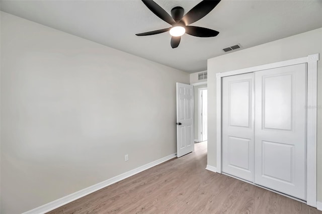 unfurnished bedroom with ceiling fan, a closet, and light wood-type flooring