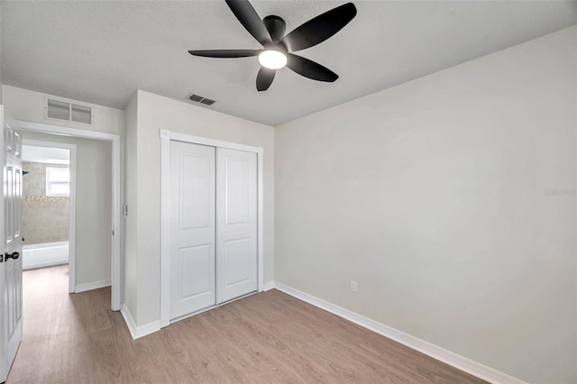 unfurnished bedroom with ceiling fan, light hardwood / wood-style flooring, and a closet