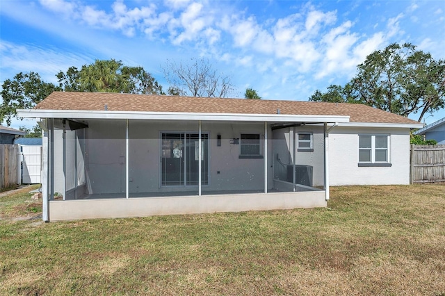 rear view of house with a sunroom and a lawn