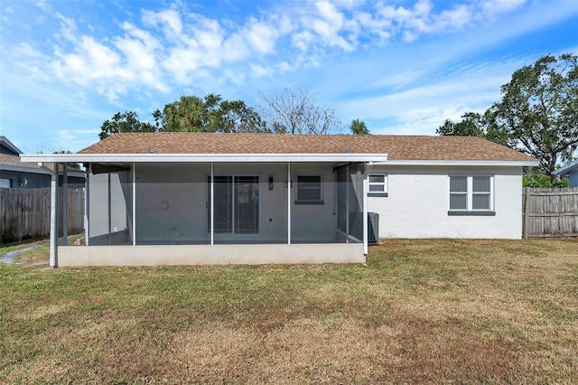 rear view of house with a sunroom and a yard