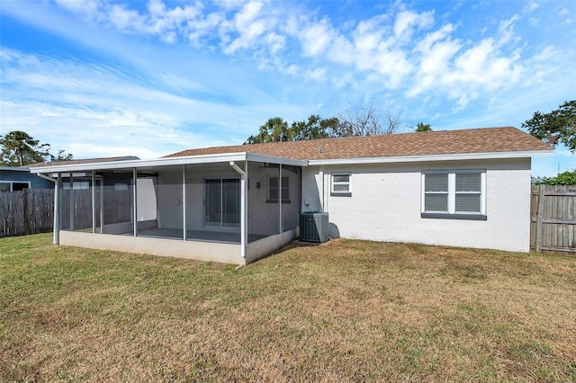 rear view of house with a sunroom, cooling unit, and a yard