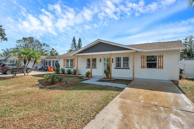 ranch-style house featuring covered porch and a front yard