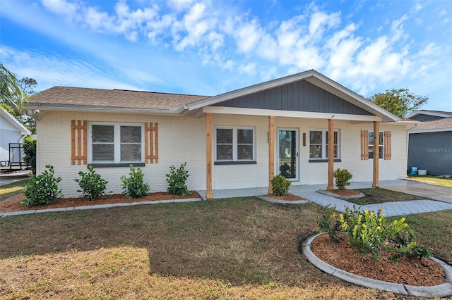 single story home featuring covered porch and a front lawn