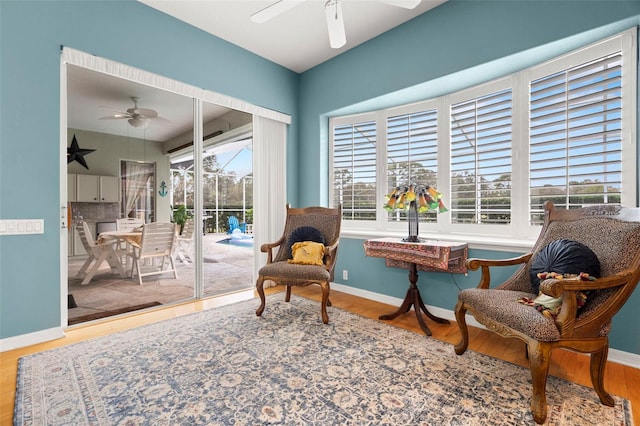 sitting room with plenty of natural light, ceiling fan, and wood-type flooring