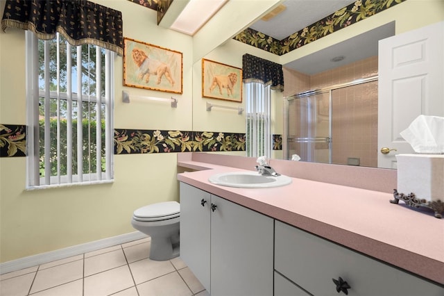 bathroom with tile patterned floors, vanity, toilet, and an enclosed shower