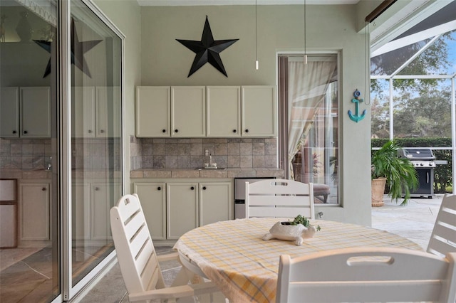 interior space with backsplash, white cabinetry, and plenty of natural light