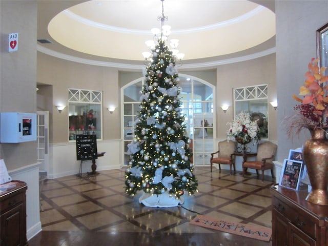 dining space with a high ceiling, a tray ceiling, tile patterned floors, and ornamental molding