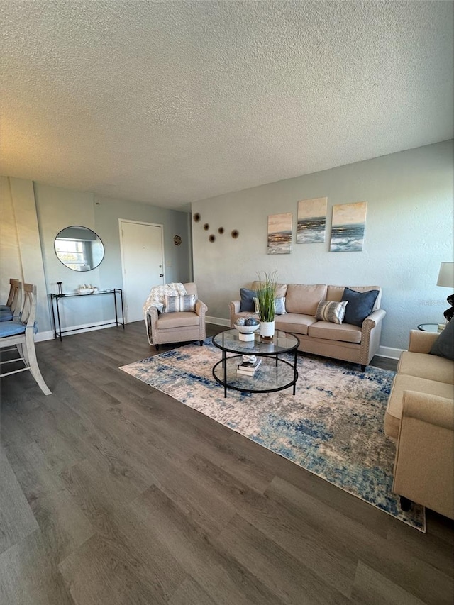 living room featuring dark wood-type flooring and a textured ceiling