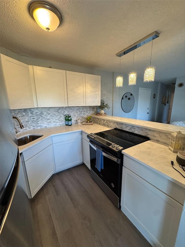 kitchen featuring electric stove, white cabinetry, decorative light fixtures, and kitchen peninsula