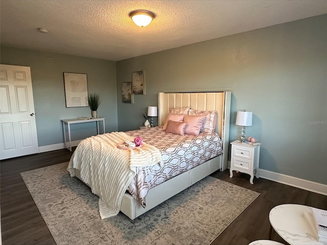 bedroom featuring a textured ceiling and dark hardwood / wood-style flooring