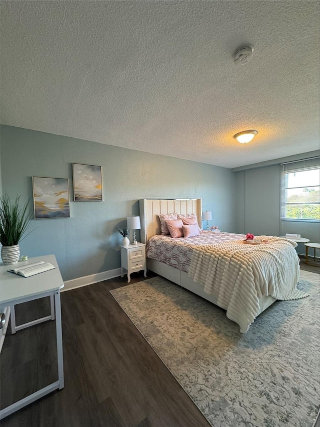 bedroom with dark wood-type flooring and a textured ceiling