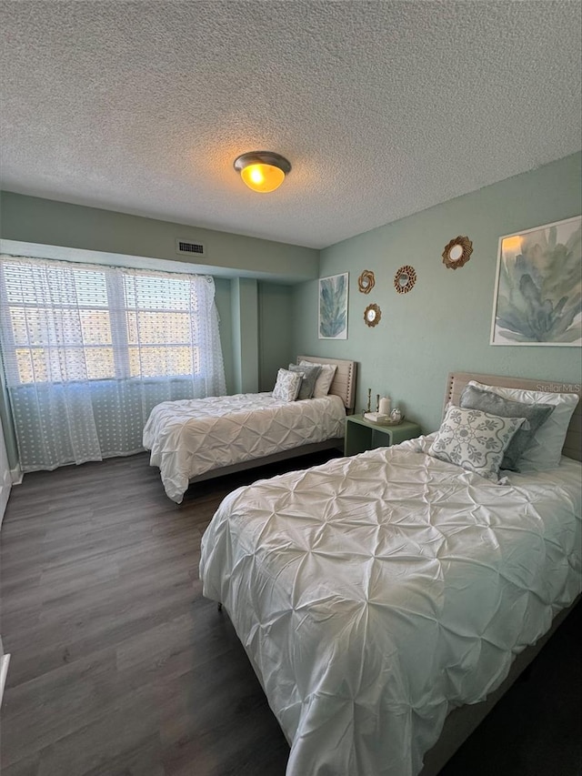 bedroom featuring dark hardwood / wood-style flooring and a textured ceiling