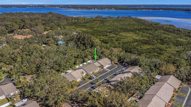 drone / aerial view featuring a residential view, a water view, and a wooded view