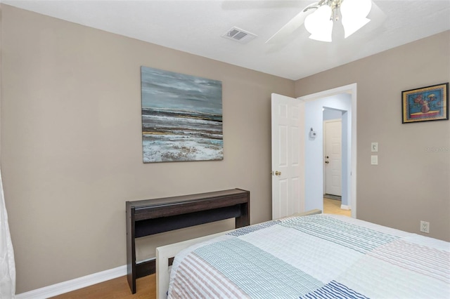 bedroom with light wood-type flooring, visible vents, baseboards, and a ceiling fan