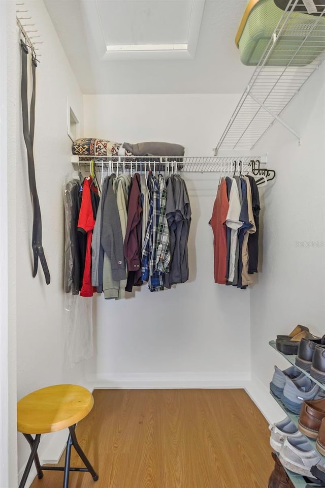 walk in closet with wood finished floors