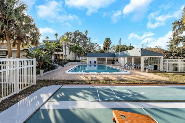 pool with a patio area and fence