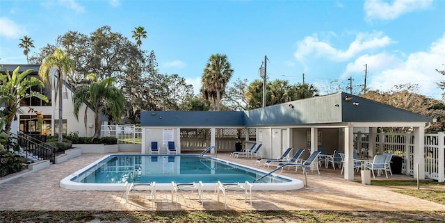 community pool with a patio and fence