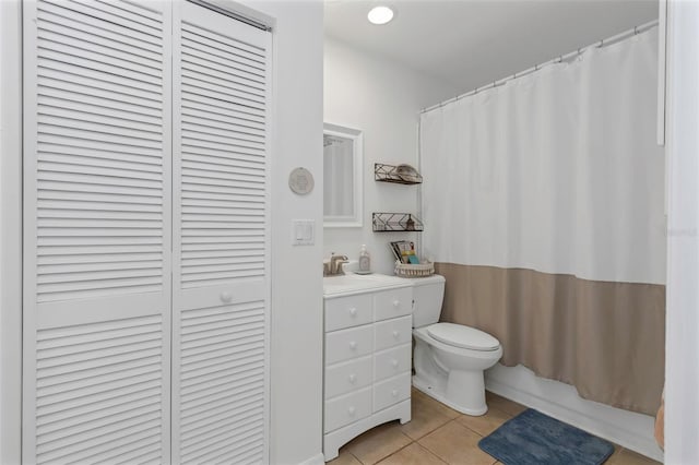 full bath with a closet, vanity, a shower with curtain, toilet, and tile patterned floors