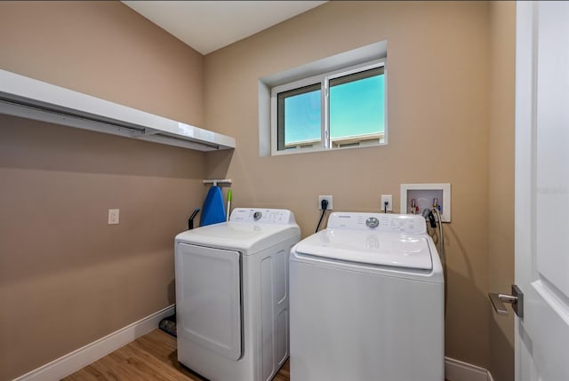 clothes washing area with light hardwood / wood-style floors and independent washer and dryer