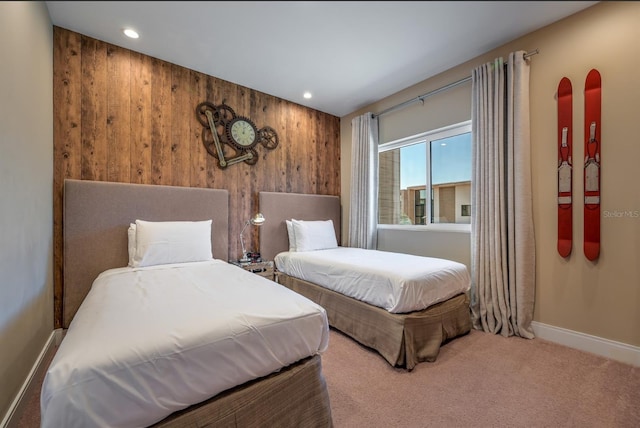 carpeted bedroom featuring wooden walls