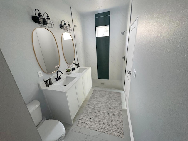 bathroom with toilet, a sink, marble finish floor, double vanity, and walk in shower