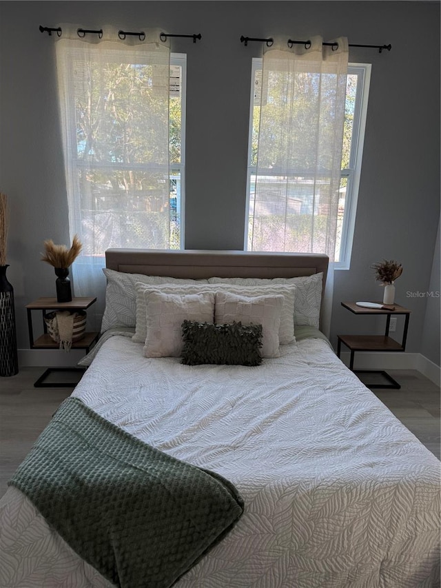 bedroom featuring wood finished floors and baseboards