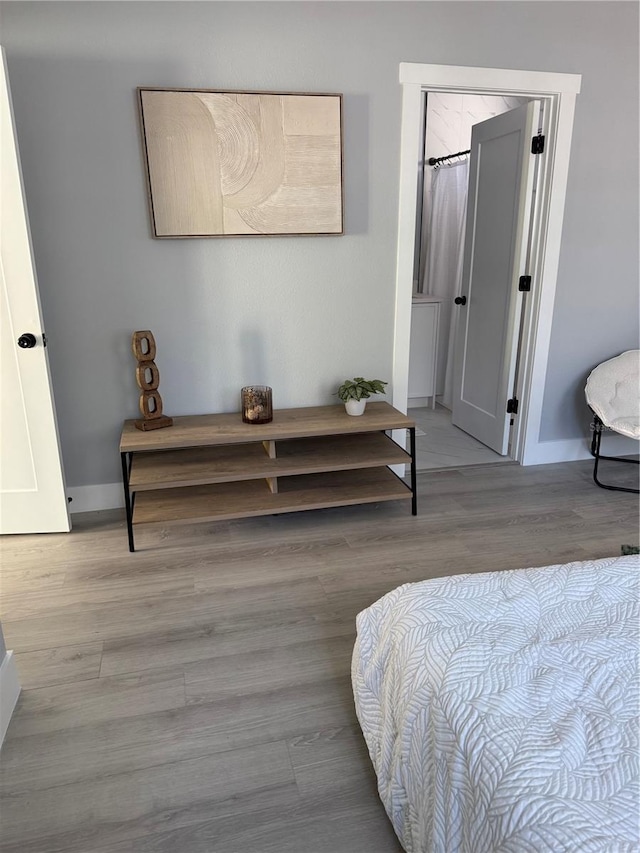 bedroom with baseboards and wood finished floors