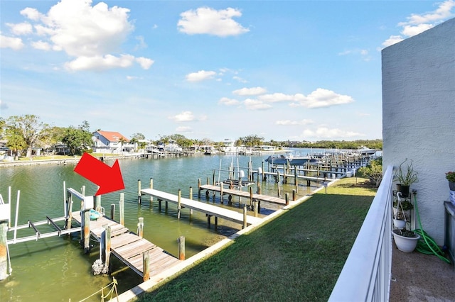 view of dock with a water view and a yard