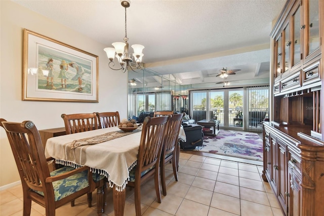 tiled dining area with beam ceiling, a textured ceiling, and ceiling fan with notable chandelier