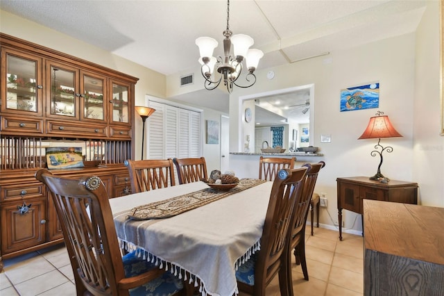 dining area featuring light tile patterned flooring, a textured ceiling, and a chandelier