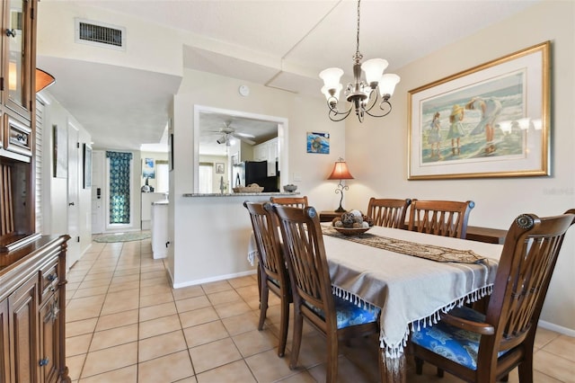 tiled dining room featuring ceiling fan with notable chandelier