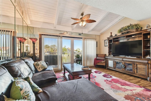 living room featuring vaulted ceiling with beams, ceiling fan, wood-type flooring, and wood ceiling