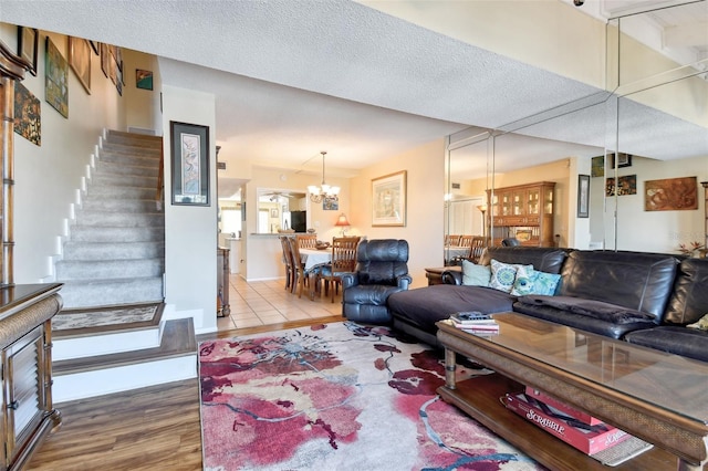 living room featuring a chandelier, hardwood / wood-style floors, and a textured ceiling