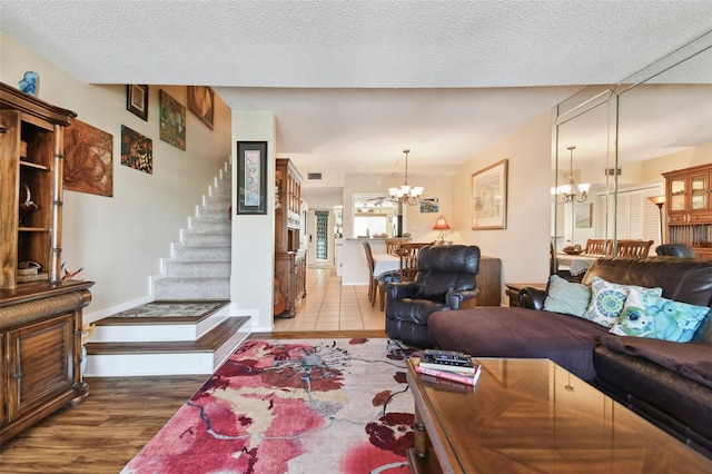 living room with a notable chandelier, wood-type flooring, and a textured ceiling