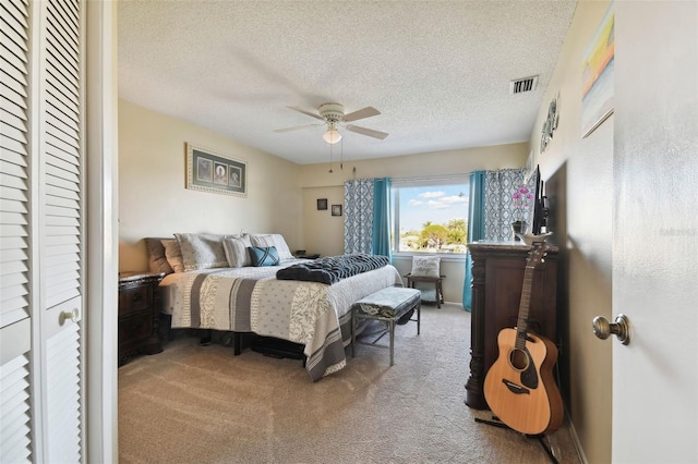 carpeted bedroom featuring a textured ceiling and ceiling fan